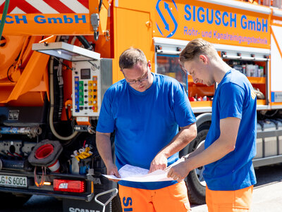 Sigusch Mitarbeiter besprechen einen Auftrag zur Rohrreinigung in Lüneburg